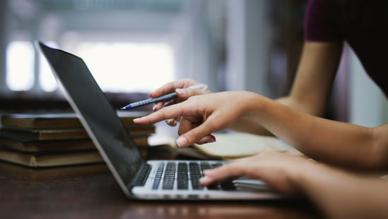 Two people at a laptop planning a Quarterly Business Review (QBR)