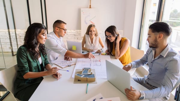 People sitting around a table discussing plans in a Quarterly business Review (QBR)