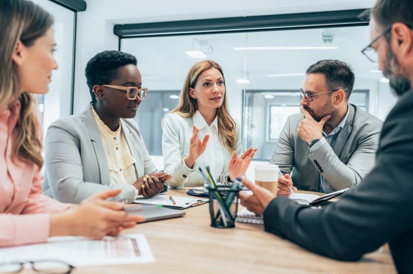 Five people in an office holding a Quarterly Business Review